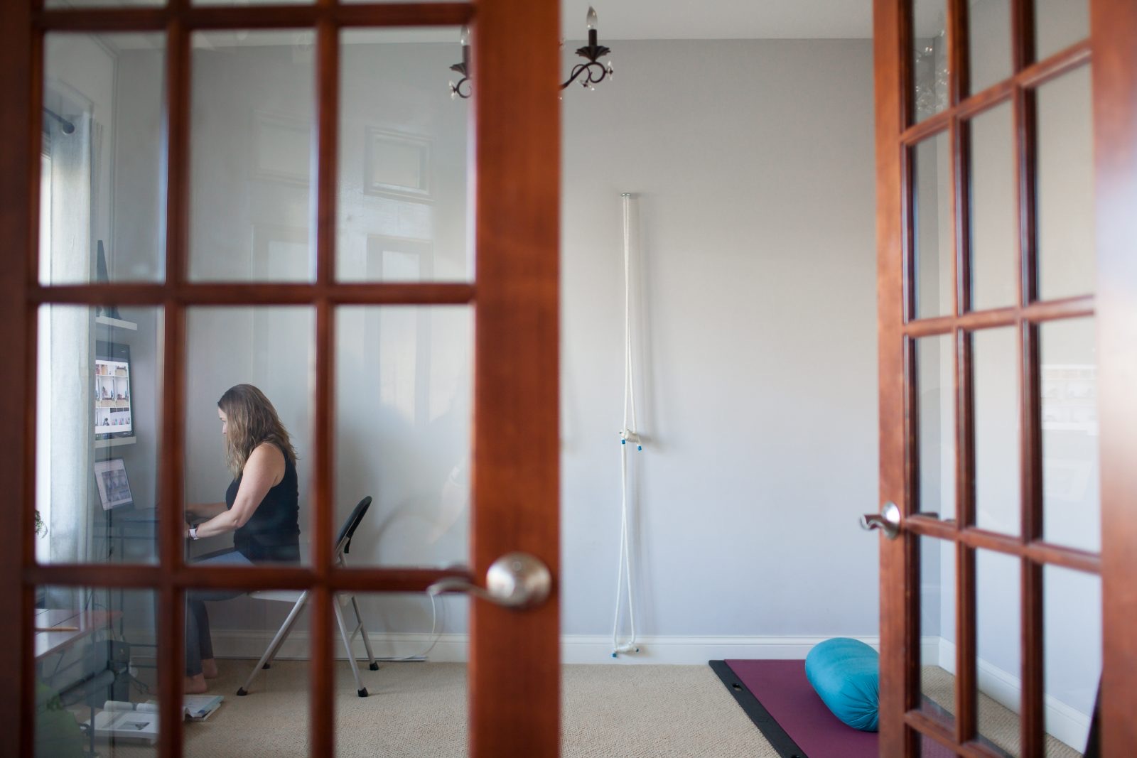 Tiffany at her workspace, seen through french doors